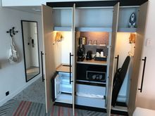 Storage space with empty minibar, iron+board, extra pillow