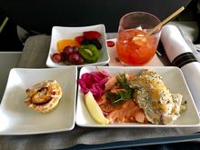 Poached salmon with fresh dill, lemon, pickled onion.  Sour cream and chive potato salad.  Side of fruit and cinnamon roll.