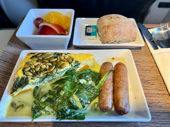 Winter Squash Frittata topped with pepitas, served with sautéed spinach and leeks, chicken cranberry sausage, warm raisin bread and fresh fruit.