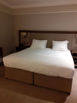 The bed ( alarm clock on right hand bed stand)