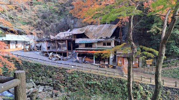 The ruins of the burnt down building ( burnt 4 days prior). Standing on the other side of the stream there was the occasional faint  burnt  odor in the air . The falls are just to the left with a couple of stands to the left. The 2nd floor viewing deck was closed 