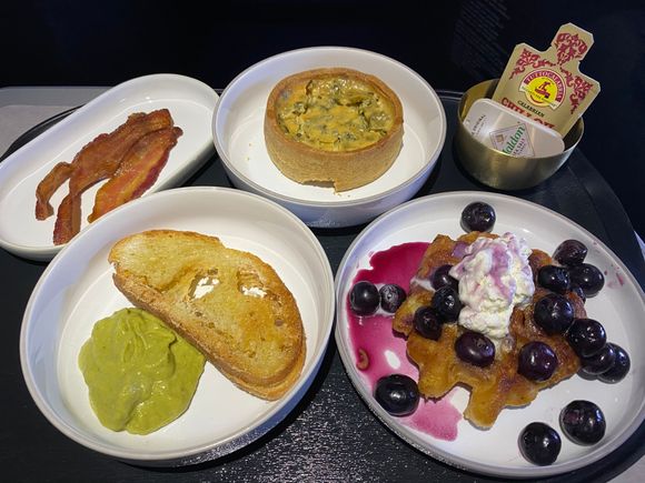Maple-glazed bacon, farm egg tart, brioche waffle, and avocado toast.