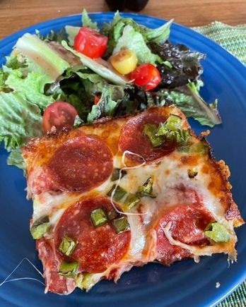 A slice of leftover Detroit style pizza and salad for lunch. 