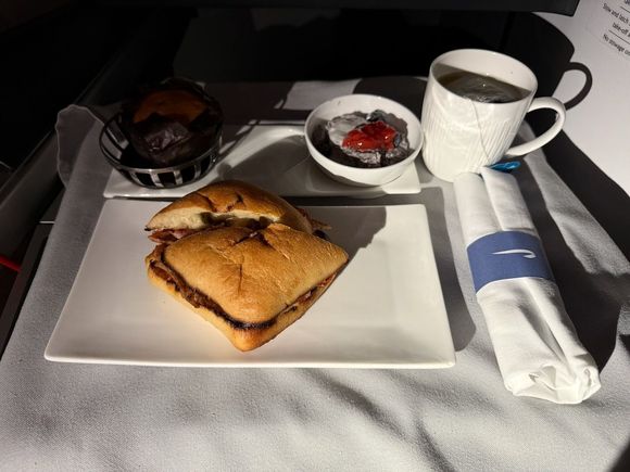 This prearrival meal was honestly pretty vile.  Sweet on sweet on sweet;  a chocolate chip muffin, a sweet chia pudding and a cloyingly sweet tomato jam on the "bacon butty" (really just two piece of bacon on a stale Costco-style ciabatta roll).  I barely ate any of this - fortunately the arrivals lounge exists as a safety school if the prearrival meal is bad going eastbound.