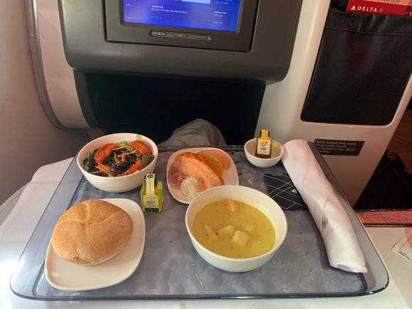 Base tray of the butternut squash soup, salad with sun-dried tomatoes, dried cherries, pumpkin seeds, appetizer and bread