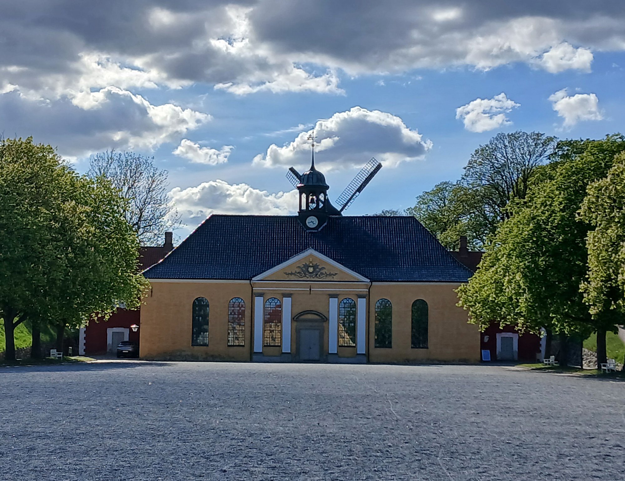 The church, the windmill sweeps visible behind the roof