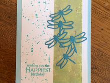 This class wil focus on masking techniques. This one is simply using painters tape to mask off the green area. Light blue and green ink are sponged on. Instead of spattering we'll use a rubber stamp that looks like spatters. The dragonflies are die cut from some sparkly blue paper. The sponge for this card is a holey man made artists sponge but we use a very fine and dense sponge to blend inks on the other cards. DH contributed scraps of upholstery foam so the class doesn,t have to buy expensive