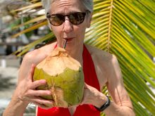 Joyce enjoying some coconut water from a hallowed out coconut 