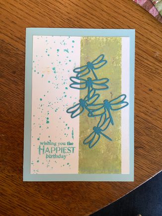 This class wil focus on masking techniques. This one is simply using painters tape to mask off the green area. Light blue and green ink are sponged on. Instead of spattering we'll use a rubber stamp that looks like spatters. The dragonflies are die cut from some sparkly blue paper. The sponge for this card is a holey man made artists sponge but we use a very fine and dense sponge to blend inks on the other cards. DH contributed scraps of upholstery foam so the class doesn,t have to buy expensive