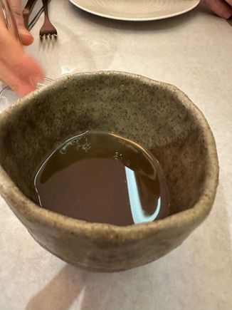 Incredibly delicious consommé presented in a handmade ceramic bowl as a complimentary first course.   A harbinger of delicious things to come!  I think the base was poultry.