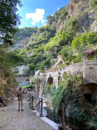 A small stream runs below the cliff at the end of town