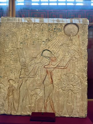 Ahkenhaten and his wife and family worshipping Aten, rhe sun god.