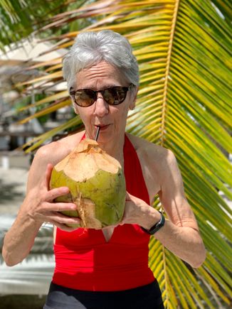 Joyce enjoying some coconut water from a hallowed out coconut 