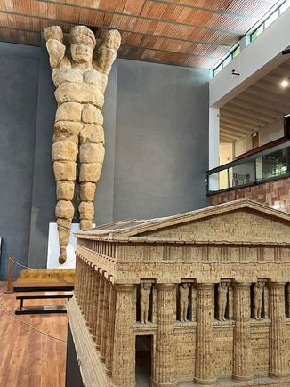 Another of the 38 telamons from the Temple of Zeus--the model in the foreground shows the positioning of them