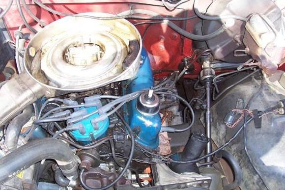 Here's a pic of the oil leak I was telling you all about.  It it all over that section of the truck.  Looks like it could be coming out of the valve cover gasket.  Do you all know what that silver thing with the spark plug popping out of it is???