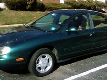 My '96 Taurus GL - Finally got a pic of it...Nothing fancy standard entry-level stock Taurus...3.0 Vulcan w AX4N tranny...Just turned over 80K...Bought it with 76.6K almost a year ago (medical limitations, so I don't drive it a whole lot)...Replaced battery, coolant reservior, sway bar linkages, new brakes and tires, tranny fluid change when I bought it (was not done @ 60K), Tune-up with new plugs and wires, radiator flush within a few days of this writing...Needs a few additional things that will be addressed as fund availability comes into play, and eventually will have a small ding in the RR door bumped out, and have it repainted the same color...Runs good...