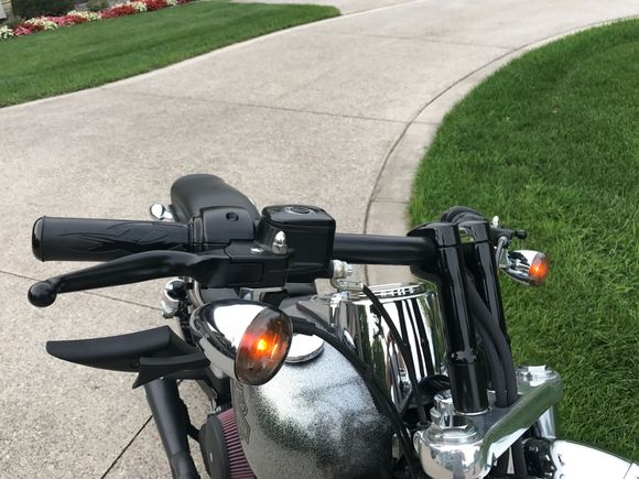 DK custom 2" risers, low profile mirrors, HD grips, black clutch and brake levers, black handlebars, custom silver metallic tank, and front fork lowering springs in this picture