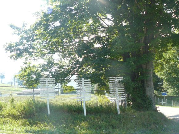The signs tell the direction and distance to different farms and houses.
