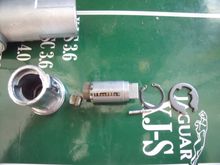 The lock barrel dis-assembled. The lock cylinder is in the center of the picture The slot in the top of the case is clearly in view with the roll pin below the cylinder snap ring