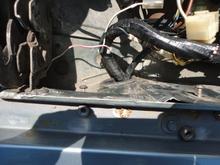 This shows the harness where it enters the engine bay with the triangular grommet reinstalled and before reattaching the starter relay bracket.