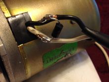 This is where I skinned off some insulation from the wires, close to the motor body. I shortened the leads on the new TVS, jammed them into the wire strands and soldered them in place.