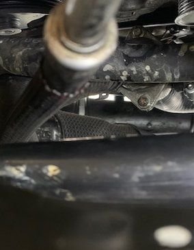 Above , Thermostat housing leaking, view from the floor. Top photo, passenger side lower radiator.  All components must me replaced.  