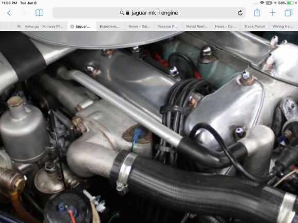 MK II 1962  What is the item in the center of the photo, just above the hose? It is triangular in shape and is bolted down with 3 bolts and has one electrical lead to it. 