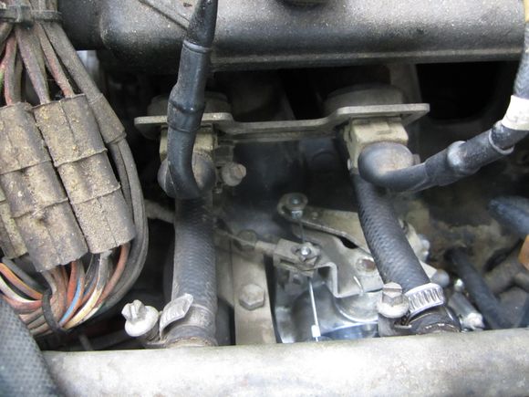 As you can see, the new cable is attached to the lower point of attachment and the upper point of attachment is connected to the cable which pulls back toward the cabin of the vehicle.