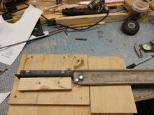 The backing bar (left) has slots cut in it so it can be adjusted for different sizes of wire. The bolt  closest to the bottom of the pic is the pivot pin. The wire bends around it. The bolt just above and right is the bolt that actually bends the wire It has to go below the top of the base so I used a Fostner drill bit and wood chisel to re-leave a slot for it in the base. 