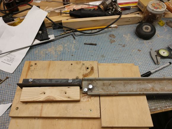 The backing bar (left) has slots cut in it so it can be adjusted for different sizes of wire. The bolt  closest to the bottom of the pic is the pivot pin. The wire bends around it. The bolt just above and right is the bolt that actually bends the wire It has to go below the top of the base so I used a Fostner drill bit and wood chisel to re-leave a slot for it in the base. 