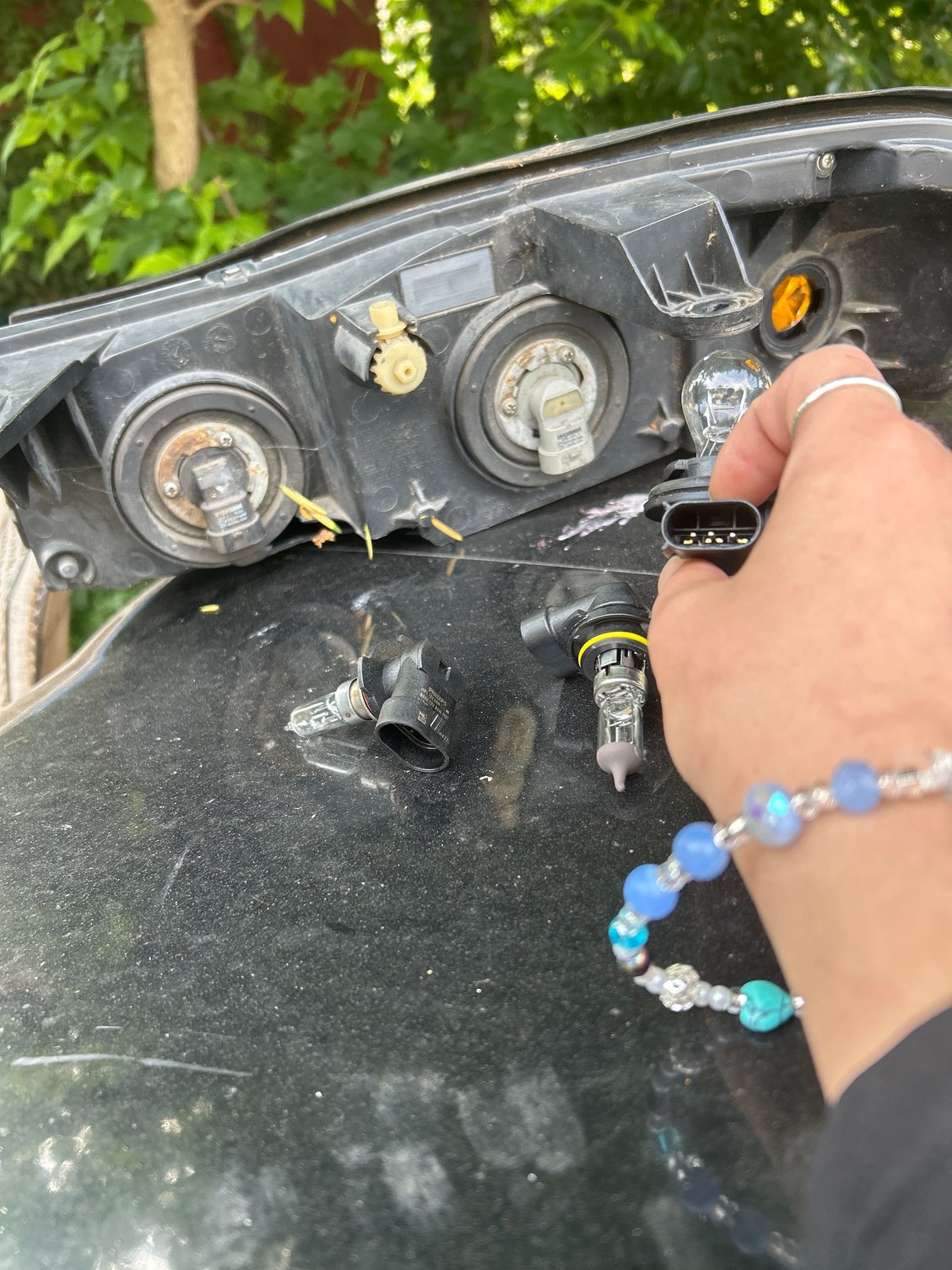 I replaced bulbs too, the ones laying on the hood and in my hand are the new bulbs 