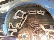 Driver side rear wheel well after body sealant but before under coating.