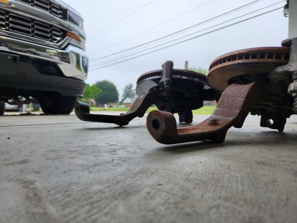 Here you can see the difference in the bent spindle(rear), and non bent(front). The top half of the rear spindle is bent up towards the rotor. The top half of the front spindle lays flat, near parallel to the floor
