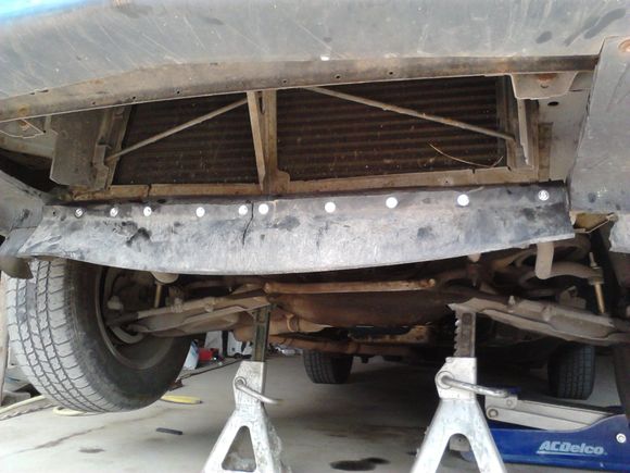 Here is the repaired air-dam. I made the repair panel out of the air-dam from a mid-'90s Camaro. I cut out a section of it, and bolted it onto the original air-dam base.
I chose to repair it instead of replacing it for a couple of reasons:
1) Cheaper
2) Any used air dam you find is probably going to be pretty beaten up after 25 years, and a new one from the dealer will be expensive (I should know, I bought one years back, but that was just because mine was completely gone, with nothing left to r