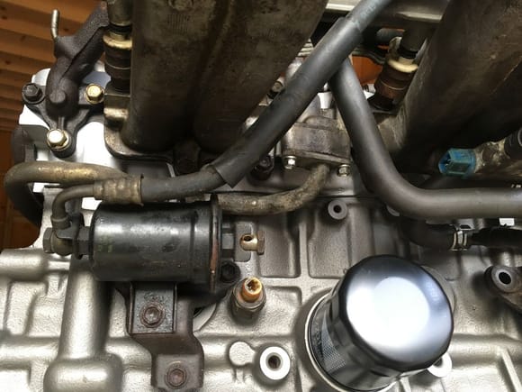i'd check the pipe just ahead of the fuel filter.. above the oil filter...that's where mine was leaking, at the gasket interface with the underside of the plenum.  the leak showed on the back edge of the bellhousing, just like yours.