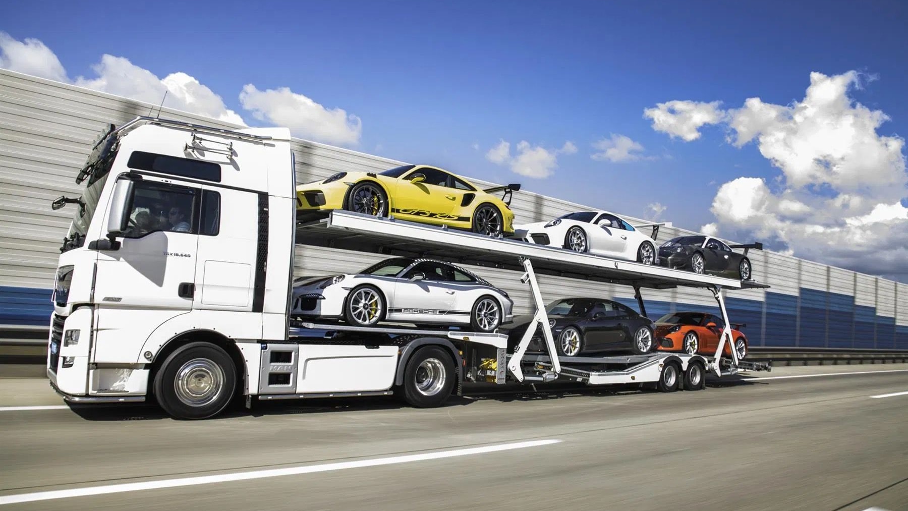 Porsche collection with transporter truck (photo via PistonHeads)