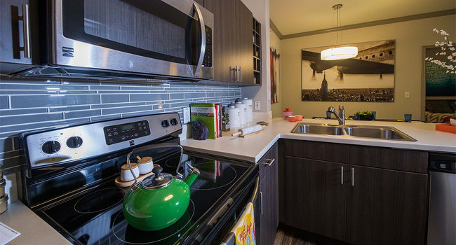 Apartment Kitchen with Stainless Steel Appliances, quartz counters and wood floors.